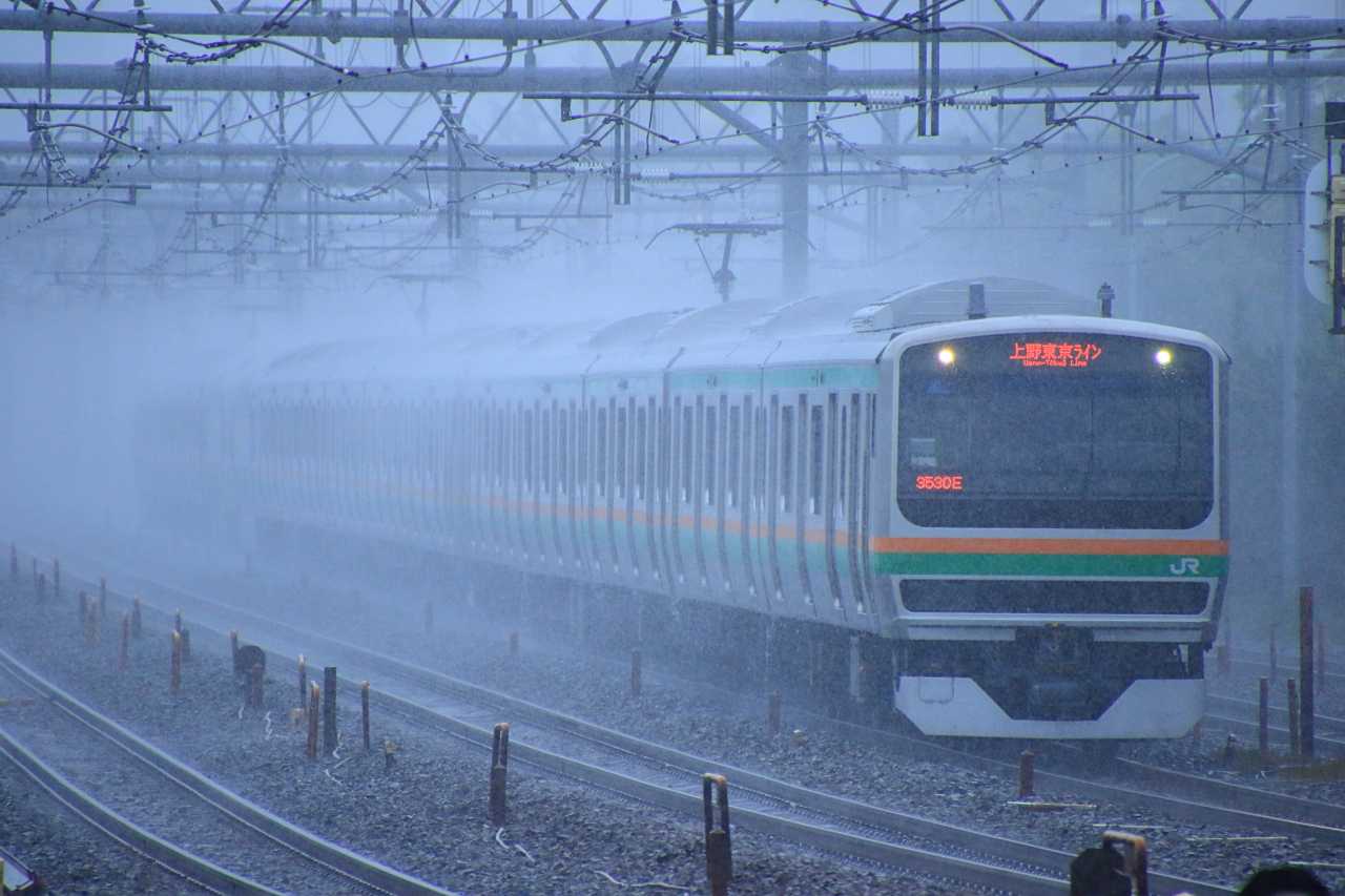 雨煙る通勤電車の写真素材