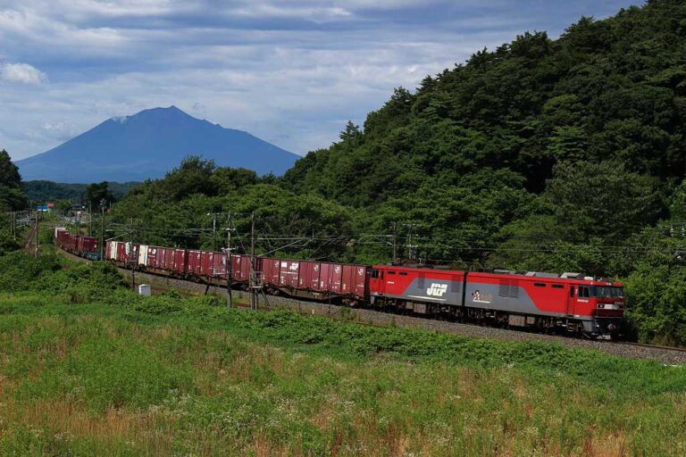 北行き貨物列車と岩手山の写真素材