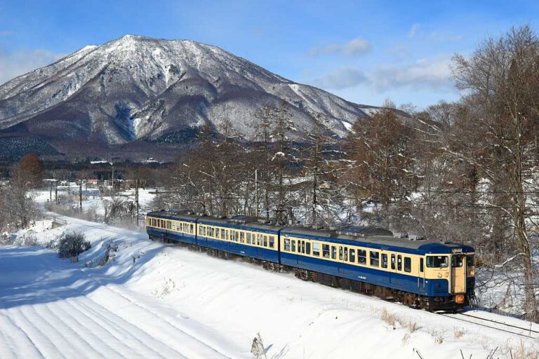 白銀のしなの鉄道と黒姫山の写真素材